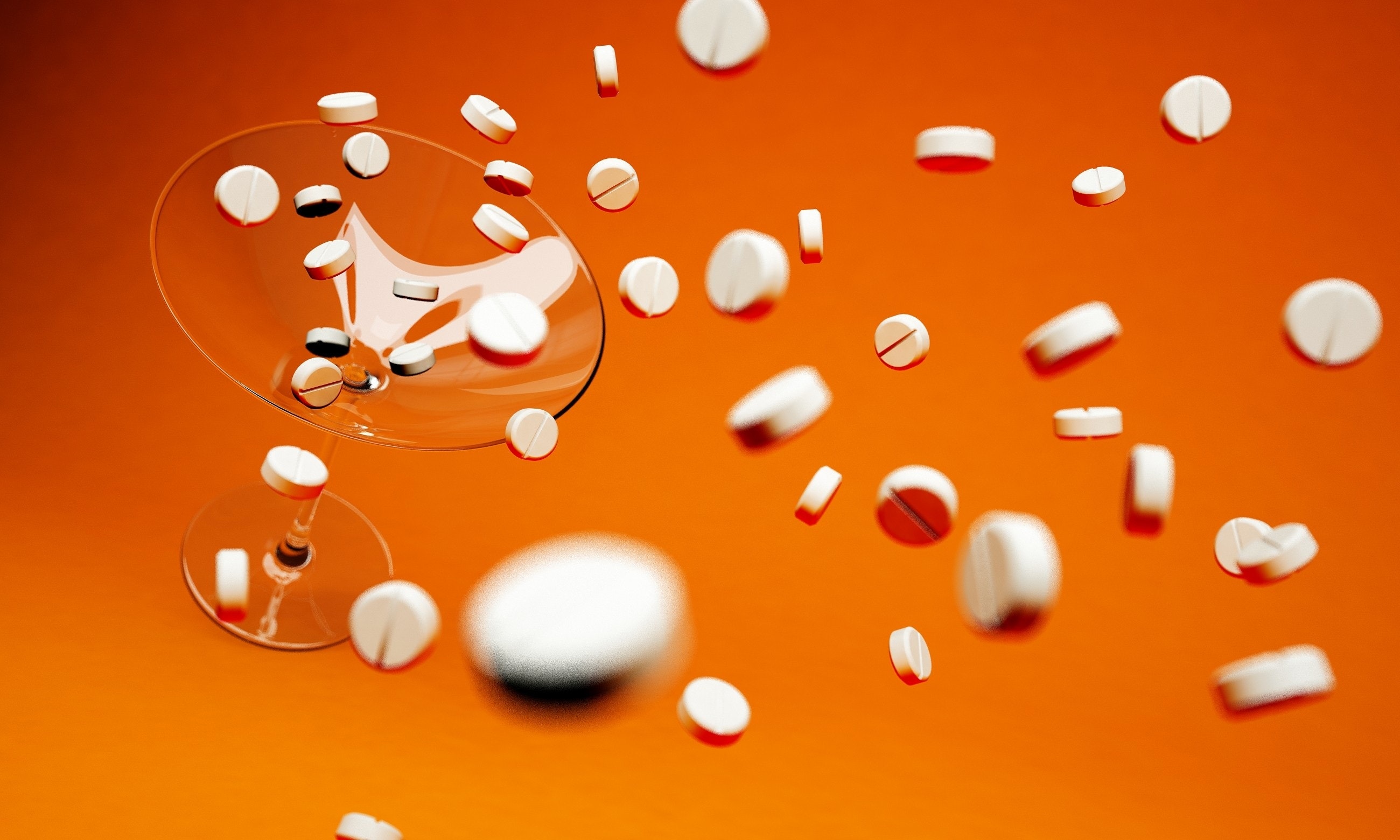 Pills falling into a martini glass